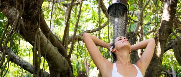 Frau unter exotischer Dusche im Freien