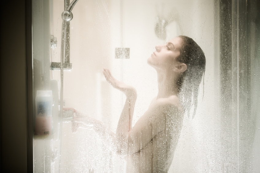 duschende Frau von Wasserdampf umgeben