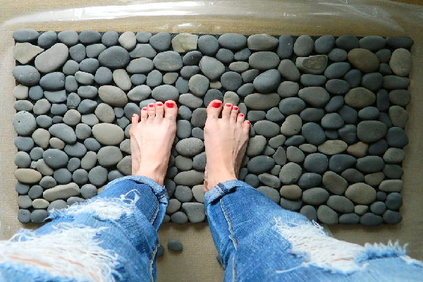 Fuesse stehend auf DIY Steinmatte