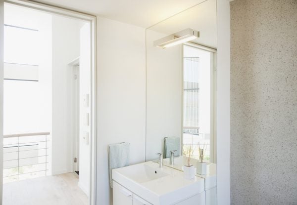 helles Badezimmer mit großem Spiegel an der Wand