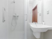 kleines helles Badezimmer mit Spiegel und Dusche