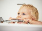 Baby in Badewanne mit Duschkopf