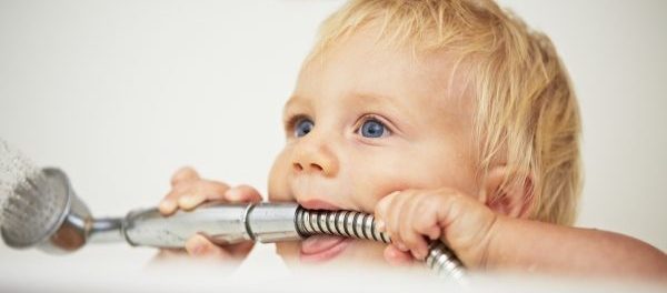 Baby in Badewanne mit Duschkopf