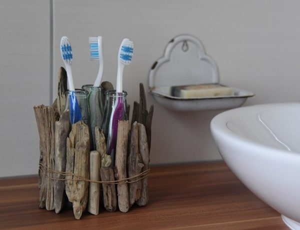 Behälter für Zahnbürsten aus Treibholz und kleinen Flaschen