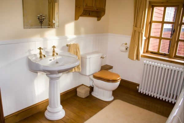 Badezimmer mit Parkett und Toilettendeckel aus Holz