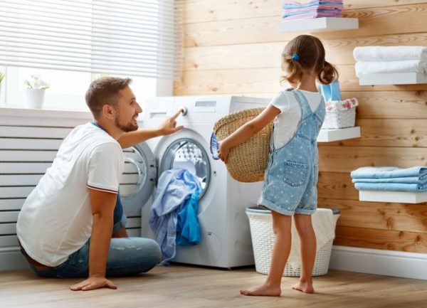 Niedlicher kleiner Junge, der zu Hause ein Fenster putzt. Kind hilft Eltern  bei der Hausarbeit, zum Beispiel beim Fensterputzen in seinem Haus. Kinder  bei der Hausarbeit. - ein lizenzfreies Stock Foto von