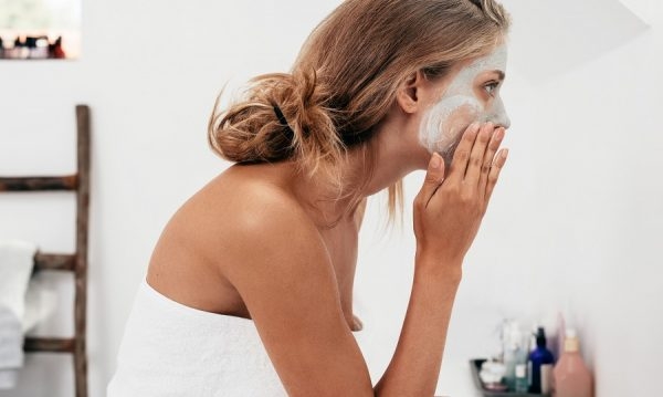 Frau trägt Gesichtsmaske auf