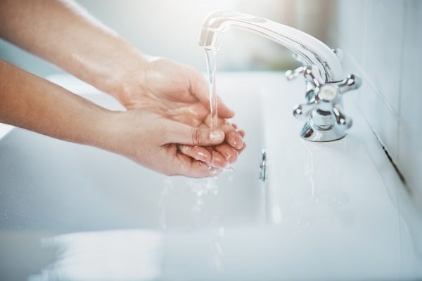 Hände unter laufendem Wasserhahn