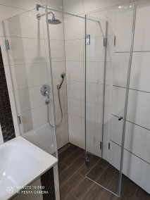Dusche neben Badewanne A2K aus Glas mit Duschrinne auf braunen Bodenfliesen 