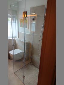 Dusche mit Falttüren F1W aus Glas bodengleich mit grauen Mosaikfliesen