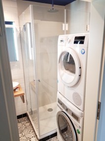 Dusche mit Falttüren F1W aus Glas in Badezimmer mit schwarz-weißem Boden