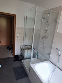 U-Dusche neben Badewanne MU2K aus Glas auf Duschwanne in grau-weißem Badezimmer